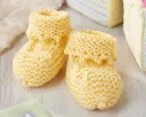 Patucos dos agujas de lana amarilla, perfectos para abrigar los pies de un bebé.