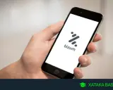 Mano sujetando un smartphone con la app Bizum abierta. Aprende como devolver un bizum fácilmente.
