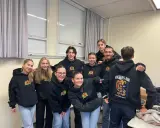 Acht lächelnde Schüler in schwarzen Hoodies mit dem Aufdruck "Volters Abi". Wie nennt man das Abitur noch?