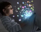 Niño de la generación alfa interactuando con iconos de aplicaciones y letras que flotan desde una tablet.
