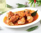 Succulento pollo alla pizzaiola con pomodoro, capperi e olive, guarnito con foglie di alloro e peperoncini secchi.