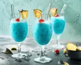 Erfrischende blaue Swimmingpool-Cocktails mit Ananas und Kirschen, bereit für den Sommer.