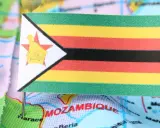 Flaga Zimbabwe na mapie, symbolizująca trudności gospodarcze i inflację.
