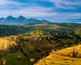 Jesienne Tatry Słowackie zachwycają kolorami. Widok na łagodne wzgórza i lasy, idealne na szlaki dla średnio zaawansowanych.
