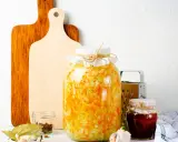 Großes Glas mit Sauerkraut, bereit zum **fermentieren im Schraubglas**. Daneben Gewürze, Knoblauch und ein kleines Glas Marmelade.