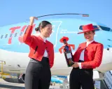Zwei Frauen in Flamenco-Kleidung am Flughafen Jerez. Eine hält eine Flasche Tio Pepe Sherry, die andere eine Peitsche.