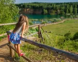 Dziewczynka na drewnianej kładce podziwia Park Gródek Jaworzno. Warto sprawdzić cenę wstępu, by cieszyć się tym widokiem!