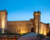 Fortezza illuminata al crepuscolo, simbolo del centro storico di Montalcino. Un'antica roccaforte che domina il paesaggio toscano.