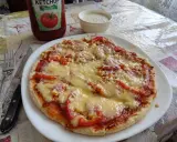 Pyszna pizza z patelni z serem, pomidorami i kukurydzą, obok ketchup i sos.