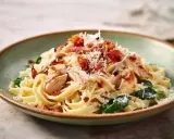 Pyszne makaron ze szpinakiem i kurczakiem, posypany parmezanem i chrupiącym boczkiem. Idealny obiad!