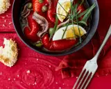 Salade de poivrons grillés avec anchois, câpres, œuf dur et herbes fraîches, servie avec du pain grillé.