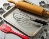 Utensilios de repostería: rodillo, batidor, espátula y varios tipos de moldes para galletas (corazón, estrella, hombrecito, círculo).