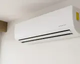 Aire acondicionado blanco con tecnología "INVERTER" montado en pared. Descubre qué significa invertir en aire acondicionado para tu hogar.