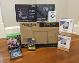 Composants pour installer un NAS : carte mère ASUS, processeur AMD Athlon, boîtier Fractal Design, alimentation, RAM Corsair, et deux disques durs Toshiba 8 To.