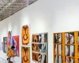 A person views colorful abstract paintings in a modern gallery, a stark contrast to a traditional museum.