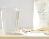 Un vaso de agua, una cuchara con bicarbonato y una bolsa de bicarbonato de sodio. ¡Listo para mezclar con vinagre!