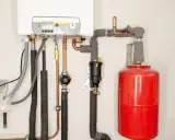 Instalacja grzewcza z kotłem i czerwonym naczyniem przeponowym. Prawidłowy dobór naczynia przeponowego zapewnia efektywną pracę systemu.