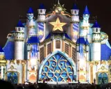 Castillo iluminado con estrellas doradas y detalles azules, evocando la magia de las **parques mágicas navidades**.