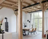Moderne umgebaute Scheune mit Holzbalken und großem Fenster. Tolle Scheune umbauen Ideen für ein helles Wohnambiente.