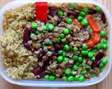 En näringsrik vegetarisk matlåda med quinoa, linser, bönor, ärtor och paprika. Perfekt för en hälsosam lunch.