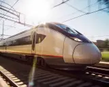 Schneller Zug nach Malaga rast auf den Gleisen. Die Sonne scheint, die Oberleitungen sind sichtbar.