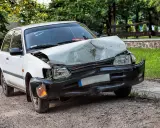 Uszkodzony biały samochód po wypadku. Zastanawiasz się ufg co to? To ubezpieczeniowy fundusz gwarancyjny, który pomaga w takich sytuacjach.