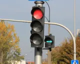 Sygnalizacja świetlna z czerwonym światłem i zielona strzałka wskazująca skręt w prawo.
