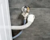 Conexión de manguera de desagüe a la pared, parte del proceso para instalar lavadora.
