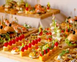 Deliciosos entrantes para boda: mini hamburguesas, canapés de salmón, brochetas de tomate y queso, y tartas saladas.