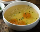 Aromaticzny rosół z perliczki, bogaty w smaku, z kawałkami marchewki i posypany natką pietruszki. Idealny na chłodne dni.