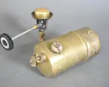 En gammal Optimus brännare i mässing, tillverkad i Sverige. Den har en tank, en brännare med lock och en veke.