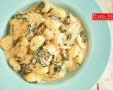 Pyszne gnocchi z kurczakiem i szpinakiem w kremowym sosie, posypane parmezanem. Idealne danie na szybki obiad.