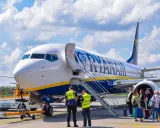 Samolot Ryanair na płycie lotniska z pasażerami i obsługą.