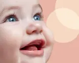 Uśmiechnięta buzia niemowlaka, jak widzi 3 miesięczne dziecko, z niebieskimi oczami i otwartymi ustami.