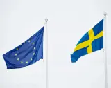 Sveriges flagga och EU-flaggan vajar sida vid sida. En symbol för samarbete inom europeiska unionen.