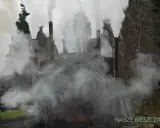 Dymiące retorty w Bieszczadach. Pracownik na szczycie jednej z nich, otoczony gęstą parą.