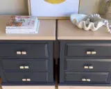 Deux tables de chevet relookées. Le bois foncé a été peint en gris anthracite, avec des poignées en rotin. Un projet réussi pour relooker un meuble en bois foncé.