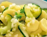 Ein köstlicher Kartoffelsalat mit Gurken, garniert mit Petersilie.