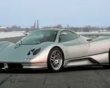 Silberner Pagani Zonda C12 steht auf einer Straße, im Hintergrund verschneite Bäume und Gebäude.