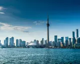 Widok na Toronto z wieżą CN i nowoczesnymi wieżowcami. Marzenie o locie do Warszawy w tle.