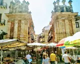 Mercato vivace a Palermo, tra bancarelle colorate e antiche architetture. Un'ottima idea per le cose da fare a Palermo, tra sapori e storia.
