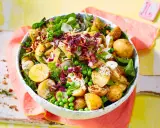 Kartoffelsalat mal anders: Ein bunter Mix aus kleinen Kartoffeln, Erbsen, Radieschen, Zwiebeln und Kräutern in einer Schüssel.