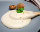 Krämig bechamelsås på en tallrik, med muskotnötter och persilja. Perfekt för ditt bechamelsås recept.
