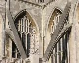 Detalle arquitectónico de una catedral gótica, mostrando la intrincada red de contrafuertes y arbotantes que sostienen sus imponentes muros y ventanas.