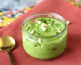 En burk med hemgjord pesto, toppad med pinjenötter. Perfekt för ditt nästa pesto recept!