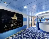 Ingresso della MSC Aurea Spa, con un'insegna dorata su sfondo nero e un tappeto blu con motivi bianchi.