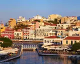 Agios Nikolaos, cosa vedere: un pittoresco porto con case colorate, ristoranti affacciati sull'acqua e un ponte pedonale.