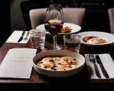 En elegant dukning med italiensk mat, vin och meny från Villa Romana, en av Stockholms bästa italienska restauranger.