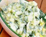 Kartoffelsalat mit Joghurt, Eiern und Gurken, garniert mit Dill. Ein cremiger und erfrischender Salat.