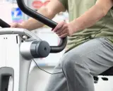 Osoba ćwiczy na rowerku stacjonarnym. Dowiedz się, ile jeździć na rowerku stacjonarnym, aby osiągnąć swoje cele.